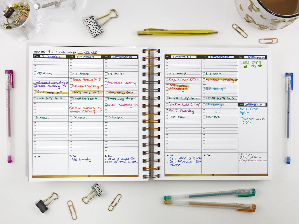 Open planner with daily schedule on a desk with office supplies