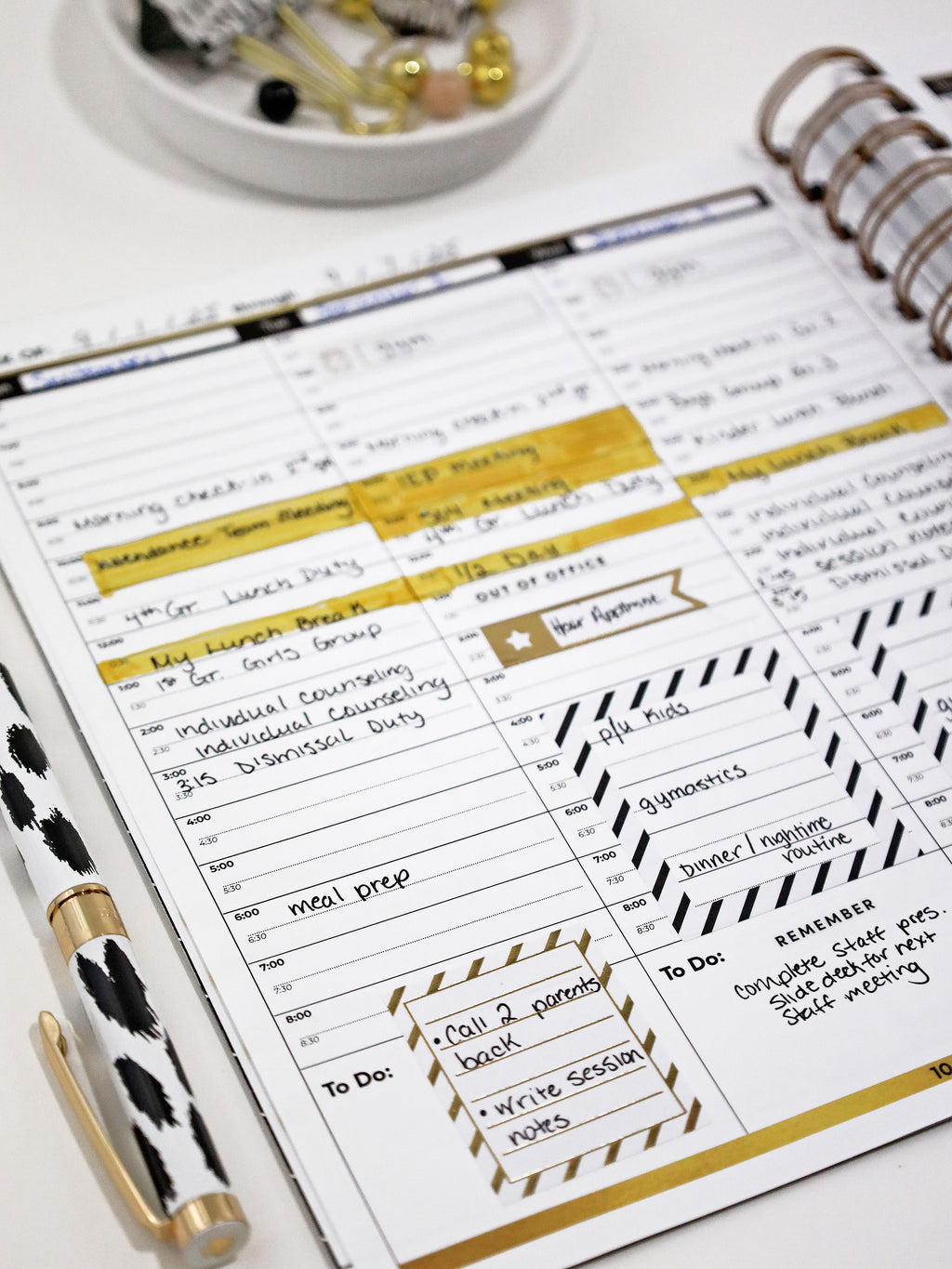 Planner with daily schedule and pen on a white surface